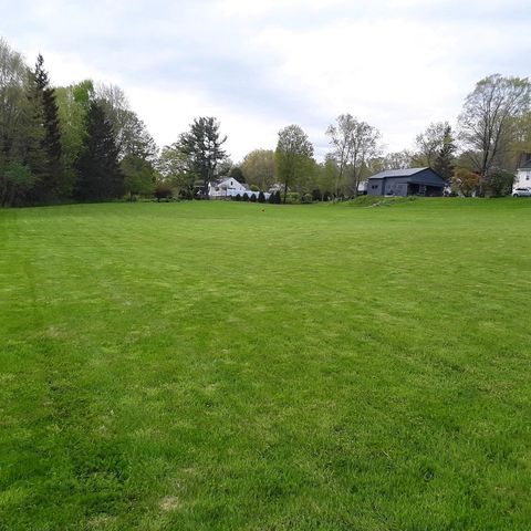 lawn with grey house in back ground