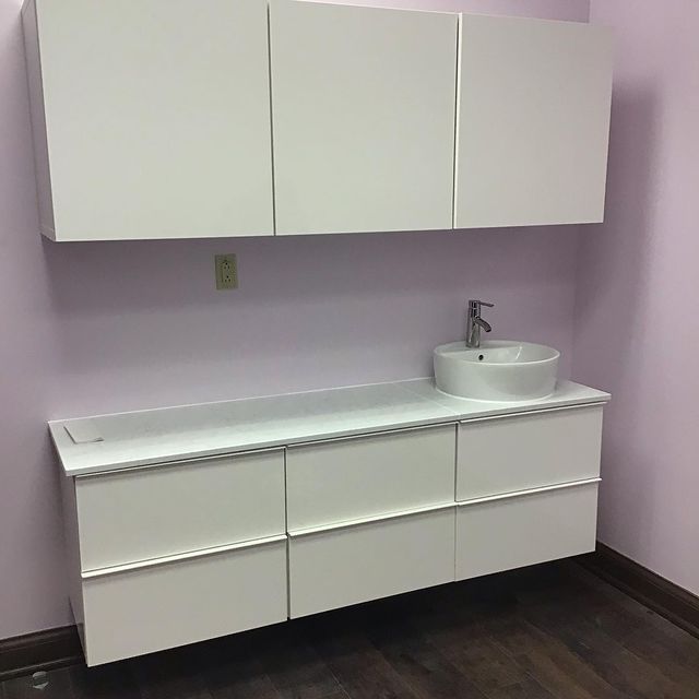 White cabinets and sink recently installed in a hair salon